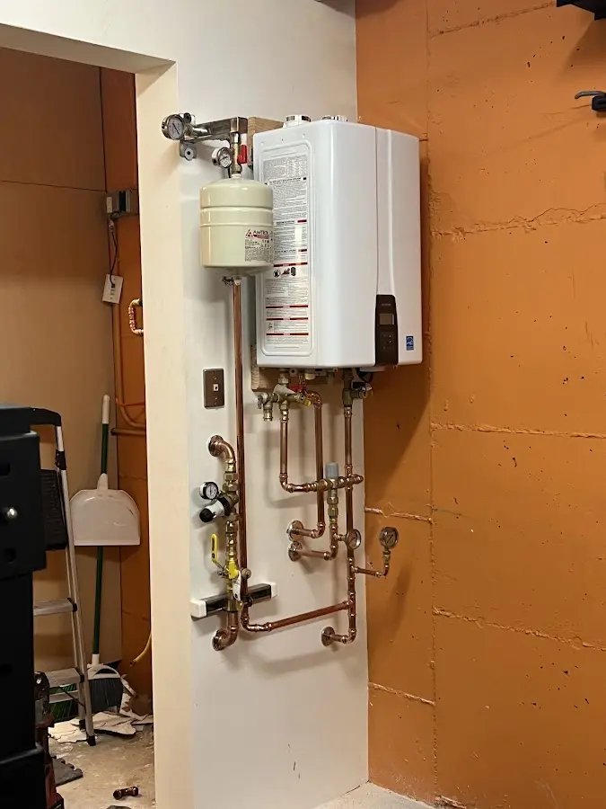 Plumbing technician inspecting water heater connections in Innsbrook